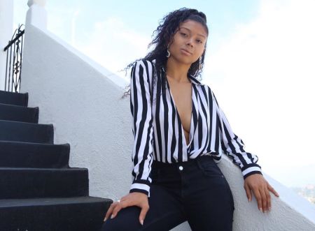 Sierra Capri in a white-black shirt poses for a photoshoot.